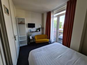 a hotel room with a bed and a window at Boutique Hotel De Raetskamer in Noordwijkerhout