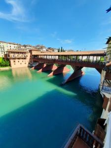 eine Brücke über einen Fluss in einer Stadt in der Unterkunft Appartamenti Ponte Vecchio in Bassano del Grappa