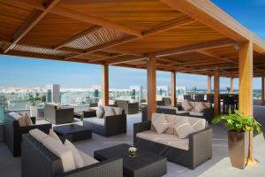 a patio with couches and tables on a building at Royal Tulip Muscat in Muscat