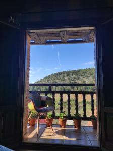 Habitación con balcón con silla y vistas. en El nido del Mirlo, en Casarejos