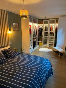 ein Schlafzimmer mit einem blauen und weißen Bett und einem Schrank in der Unterkunft Loft 10 personnes centre de Blois avec jacuzzi in Blois