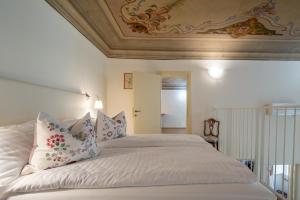 a bedroom with a large white bed with pillows at Palazzo D'Ambra Residenza d'Epoca in Florence