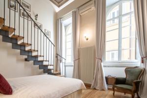 a bedroom with a staircase and a bed and a chair at Palazzo D'Ambra Residenza d'Epoca in Florence