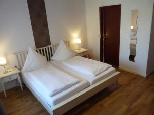 sypialnia z łóżkiem z białą pościelą i poduszkami w obiekcie Pension Haus Baltic w mieście Dahme