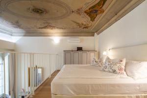 a bedroom with a large white bed with a ceiling at Palazzo D'Ambra Residenza d'Epoca in Florence