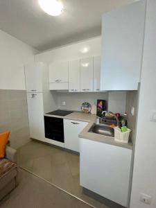 a kitchen with white cabinets and a sink at Sladjawing1 in Jagodina