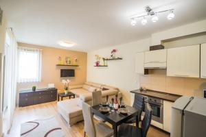 eine Küche und ein Wohnzimmer mit einem Tisch und einem Sofa in der Unterkunft MF Solaris Family Apartment in Siófok