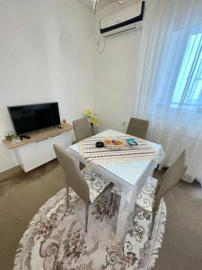 a dining room with a white table and chairs at Sladjawing1 in Jagodina