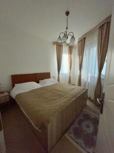 a bedroom with a large bed with curtains and a chandelier at Sladjawing1 in Jagodina