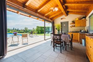 een keuken en eetkamer met uitzicht op een patio bij Il casotto nelle Langhe in Farigliano