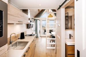 a kitchen with white counters and a large window at Thalassa Beach Houses in Zandvoort