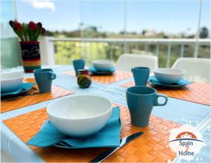 een tafel met kommen en bekers op een blauwe tafeldoek bij Atico Las Palmeras Golf by Spain2home in Vélez-Málaga