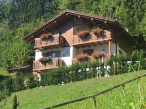 una casa con balcones y flores en una colina en Casa Vacanze Villa Elena en Alleghe