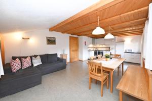 a living room with a black couch and a table at Bauernhof Bilgeri in Hittisau