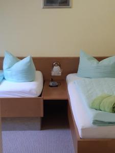 2 Betten mit blauen Kissen nebeneinander sitzen in der Unterkunft Kurparkstübl Bad Schandau in Bad Schandau