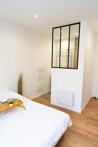 um quarto branco com uma cama grande e uma janela em Appartement chaleureux proche gare em Saumur