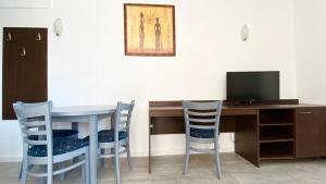 a table and chairs with a television and a desk at Carina Beach in Sunny Beach