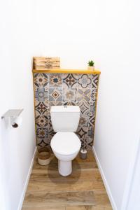 een badkamer met een toilet en een tegelwand bij Appartement chaleureux proche gare in Saumur