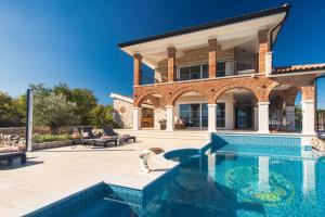ein Haus mit einem Swimmingpool vor einem Haus in der Unterkunft Villa Santa Maria in Vrbnik