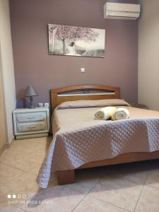 sypialnia z łóżkiem i nocną szafką z narzutą w obiekcie Eliza Apartment w Lixoúrion