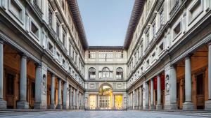 um corredor vazio num edifício com colunas em Historic center Palace - Huge 4 bedrooms Santa Croce apartment apartment - AC in all rooms em Florença