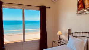 sypialnia z łóżkiem i widokiem na ocean w obiekcie Beira Mar by Check-in Portugal w Albufeirze