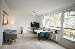 a living room with a table and chairs and a tv at Ostseehaus Dreesen in Timmendorfer Strand