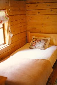 Łóżko w drewnianym pokoju z oknem w obiekcie Niidupuu Camping w mieście Mändjala