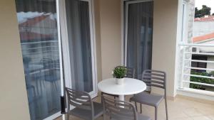 uma mesa branca e cadeiras numa varanda com uma janela em Rita Apartments - Sea-view apartment 2plus1 em Tučepi