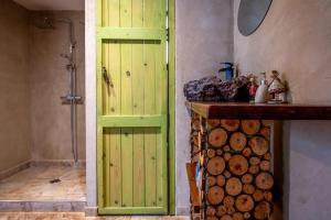 a bathroom with a green door next to a pile of logs at Paradise on the horizon in El-Rom +54 photos