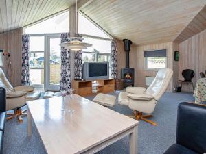ein Wohnzimmer mit einem Tisch und Stühlen sowie einem TV in der Unterkunft Holiday home Idestrup in Bøtø By