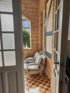 a small balcony with two chairs and a window at Villa De Panne in De Panne