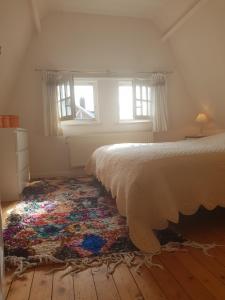 a bedroom with a bed and a rug on the floor at Villa De Panne in De Panne