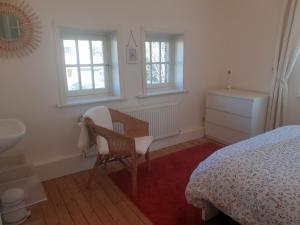 a bedroom with a bed and a chair and a sink at Villa De Panne in De Panne