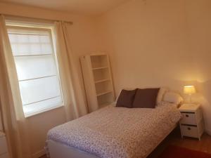 a small bedroom with a bed and a window at Villa De Panne in De Panne