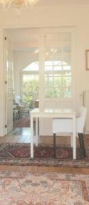 a white table and a chair in a room at Villa De Panne in De Panne