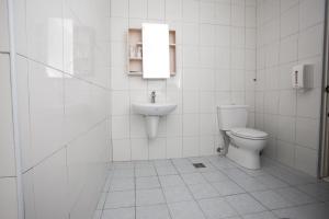 永康區的住宿－台南華南商旅，白色的浴室设有卫生间和水槽。