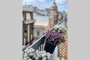 a balcony with flowers in a pot on a railing at laus via sparano - lux & design mini in Bari