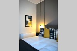 ein Schlafzimmer mit einem Bett mit gelben und schwarzen Kissen in der Unterkunft laus via sparano - lux & design mini in Bari