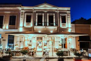 a restaurant with tables and umbrellas in front of a building at Espero Royal Stay in Nafplio