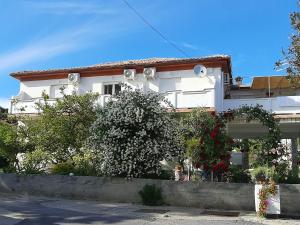 a white house with flowers in front of it at Rooms Pipo in Rab