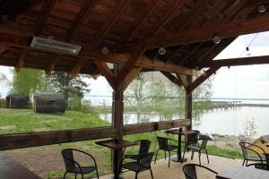 d'une terrasse avec des chaises et des tables et une vue sur le lac. dans l'établissement Hara Sadama iglukämping, à Hara