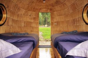 2 letti in una camera in legno con finestra di Hara Sadama iglukämping a Hara