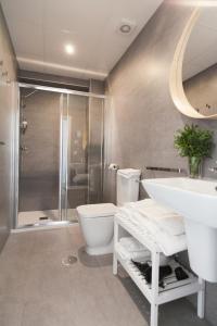 een badkamer met een wastafel, een toilet en een douche bij GoToSeville Molviedro Suites in Sevilla