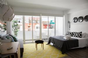 GoToSeville Molviedro Suites في إشبيلية: غرفة نوم بسرير ونافذة كبيرة