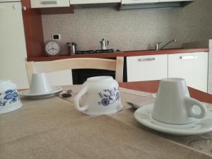 a table with three tea cups and plates on it at Tra le cummerse in Locorotondo