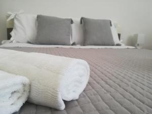 een slaapkamer met 2 bedden met witte lakens en kussens bij Tra le cummerse in Locorotondo