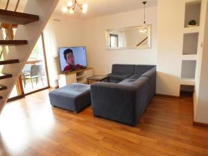 a living room with a couch and a tv at Willa Dom wakacyjny Zakątek in Kołobrzeg