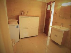 a small white kitchen with a sink and a refrigerator at Willa Dom wakacyjny Zakątek in Kołobrzeg +24 photos