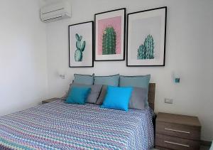 a bedroom with a bed with four pictures on the wall at Dreaming Sorrento Suites in Sorrento